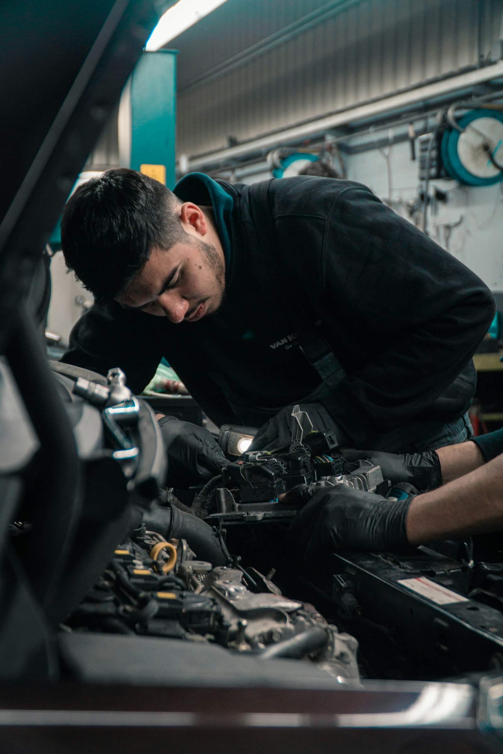 Mecánico trabajando en el motor de un coche en el taller